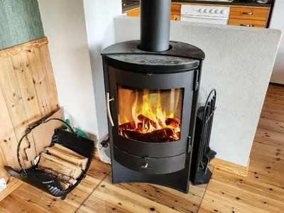 a stove with a fire in a room at 9 person holiday home in MOSTERHAMN-By Traum in Mosterhamn