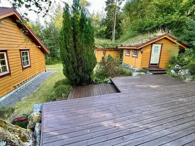 a wooden deck in front of a cabin at 9 person holiday home in MOSTERHAMN-By Traum in Mosterhamn