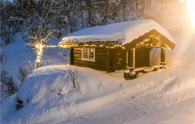 a small cabin covered in snow with christmas lights at 4 Bedroom Nice Home In Hemsedal in Hemsedal