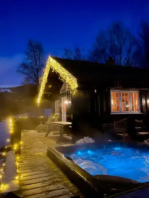 a house with a christmas lights around a swimming pool at Three bedroom holiday house with jacuzzi in Bjorli , pets allowed in Bjorli