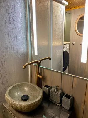 a bathroom with a stone sink and a mirror at Three bedroom holiday house with jacuzzi in Bjorli , pets allowed in Bjorli