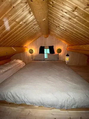 a bed in a small room with a wooden ceiling at Three bedroom holiday house with jacuzzi in Bjorli , pets allowed in Bjorli