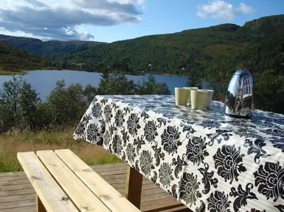 a blue and white table with a view of a lake at Panoramahytte in Norheimsund