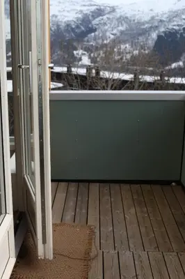 an open door with a view of a snowy mountain at Hordatun Apartments in Røldal