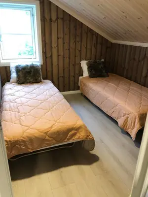 a bedroom with two beds and a window at Storekleiv Hyttefelt Tuddal in Tuddal
