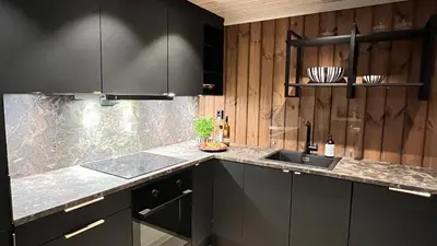a kitchen with black cabinets and a counter top at Storekleiv Hyttefelt Tuddal in Tuddal