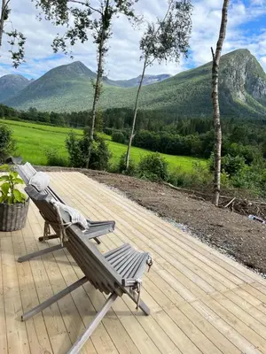 a bench on a deck with mountains in the background at Kavliskogen panorama in Isfjorden
