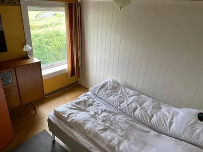a bedroom with a bed and a window at Feriehus i landlige område med nydelig utsikt in Leirvik