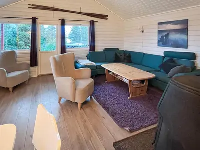 a living room with a couch and a table and chairs at 6 person holiday home in bremnes-By Traum in Bremnes