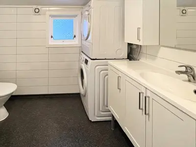 a white kitchen with a sink and a washing machine at 6 person holiday home in bremnes-By Traum in Bremnes