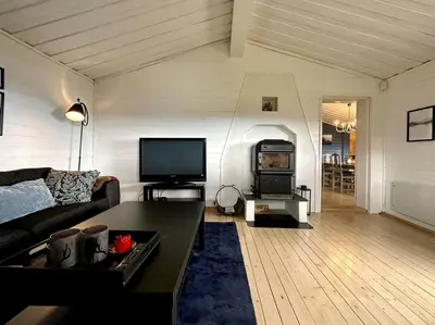 a living room with a couch and a flat screen tv at Large cabin Sjusjøen XC ski in out & lovely view in Ringsaker