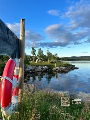 a boat sitting on the side of a body of water at Large cabin Sjusjøen XC ski in out & lovely view in Ringsaker