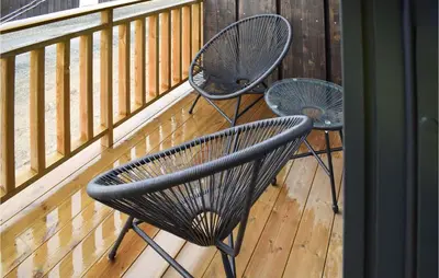 two chairs sitting on a deck next to a balcony at Cozy Home In Rauland With Sauna in Torvetjørn