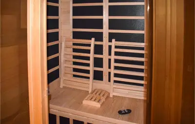 a glass door to a sauna with two chairs in it at Cozy Home In Rauland With Sauna in Torvetjørn