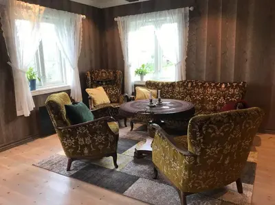 a living room with couches and a table and chairs at The Olav-house from 1840, at farm Ellingbø in Vang I Valdres