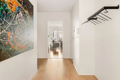 a white hallway with a large painting on the wall at Dinbnb Apartments I Luxury with Views l Large Balcony in Bergen