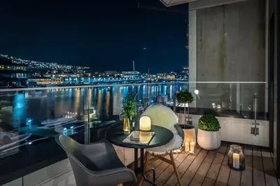 a balcony with a view of a city at night at Dinbnb Apartments I Luxury with Views l Large Balcony in Bergen