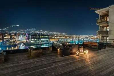 a view of a city from a deck at night at Dinbnb Apartments I Luxury with Views l Large Balcony in Bergen