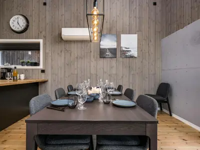a dining room with a table with chairs and a clock at Holiday Home Mathias by Interhome in Vik