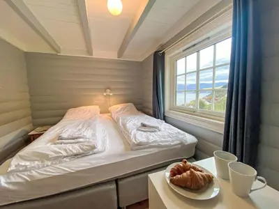 a bed in a room with a window and a table at Chalet Krampehaugen by Interhome in Utvik