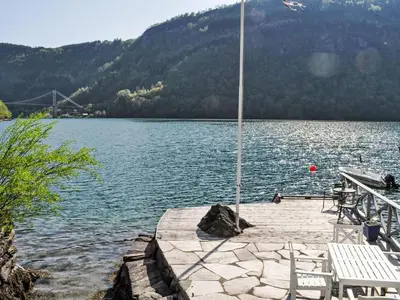 a dock with two white chairs on a lake at Holiday Home Ørviksnes by Interhome in Steinstø
