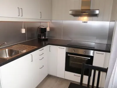 a kitchen with white cabinets and a stove top oven at Holiday Home Sognesjö by Interhome in Bø