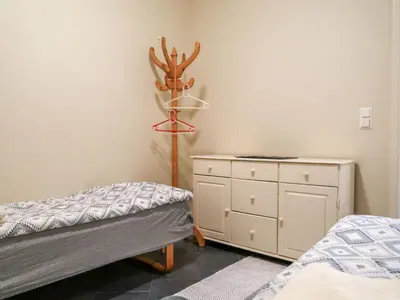 a bedroom with two twin beds and a dresser at Apartment Heningen by Interhome in Uggdal
