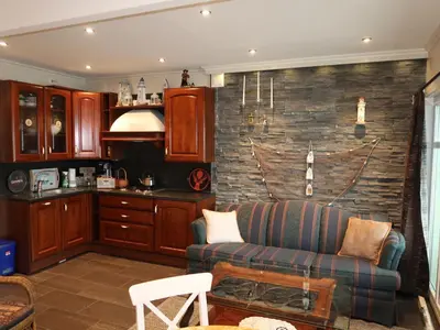 a living room with a couch and a stone wall at Apartment Heningen by Interhome in Uggdal