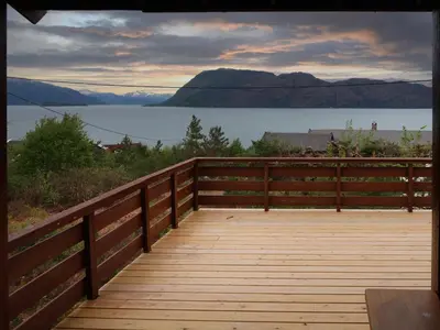 a wooden deck with a view of a lake at Chalet Trefall by Interhome in Gausvik