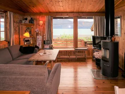 a living room with a couch and a large window at Chalet Trefall by Interhome in Gausvik