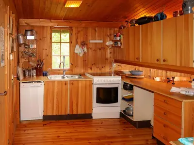 a kitchen with wooden cabinets and a white stove top oven at Chalet Trefall by Interhome in Gausvik