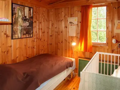 a bedroom with wooden walls and a bed in a room at Chalet Trefall by Interhome in Gausvik