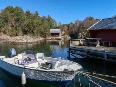 a boat docked at a dock next to a building at Holiday Home Sjøhytta by Interhome in Bekkjarvik