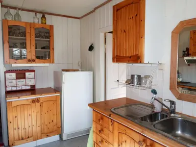a kitchen with wooden cabinets and a white refrigerator at Holiday Home Sjøhytta by Interhome in Bekkjarvik