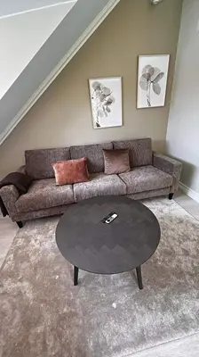 a living room with a couch and a table at Bo i historisk bygning, kort vei til sentrum in Trondheim