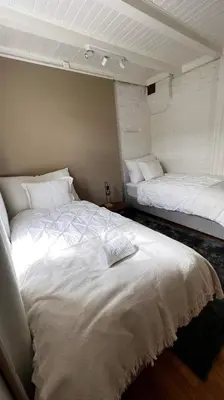 a bedroom with two beds with white sheets at Bo i historisk bygning, kort vei til sentrum in Trondheim
