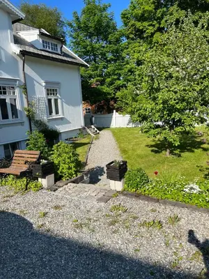 a house with a pathway leading to a yard at Bo i historisk bygning, kort vei til sentrum in Trondheim