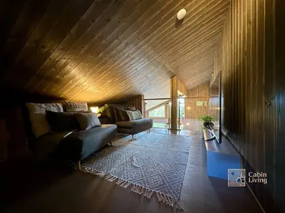 a living room with two couches and a table at Sjusjøen ski in out, ski storage, Wifi, grill & fireplace, modern apartment! in Sjusjøen