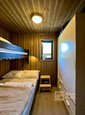 a bedroom with a bed in a wooden cabin at Sjusjøen ski in out, ski storage, Wifi, grill & fireplace, modern apartment! in Sjusjøen