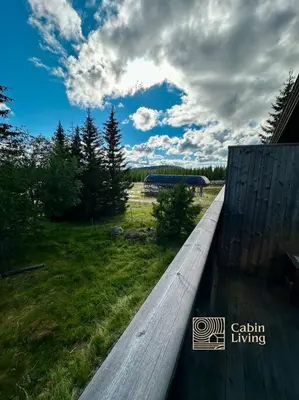 a wooden fence in a field with a cloudy sky at Sjusjøen ski in out, ski storage, Wifi, grill & fireplace, modern apartment! in Sjusjøen