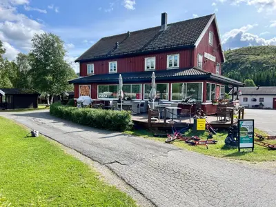 a large red house on the side of a road at Gullvåg Camping Nyberg in Soknedal