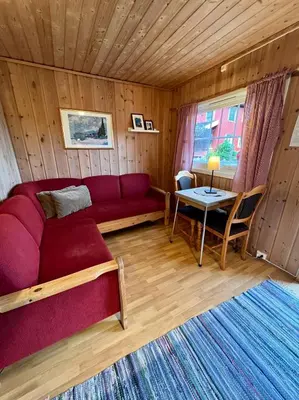 a living room with a red couch and a table at Gullvåg Camping Nyberg in Soknedal