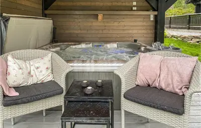 a hot tub with two chairs and a table at Nice Home In Sykkylven With Kitchen in Sykkylven