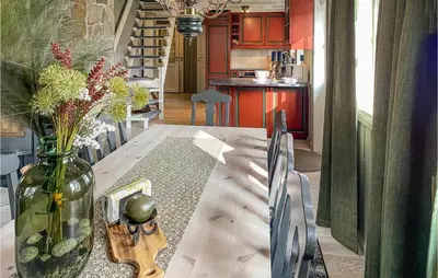 a dining room with a table with a vase of flowers at Nice Home In Sykkylven With Kitchen in Sykkylven