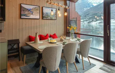 a dining room with a table and chairs and a window at Nice Home In Straumgjerde in Riksem