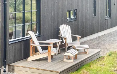 two chairs sitting on a deck next to a building at Pet Friendly Home In Trysil With Wifi in Trysil