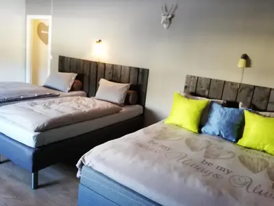 two beds in a room with yellow and blue pillows at Løvheim Gjestehus in Sauland