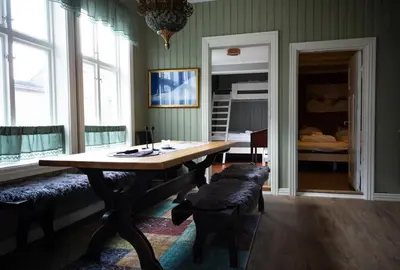 a dining room with a table and a bed at Skanckegårdene AS in Røros