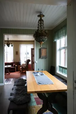 a dining room with a wooden table and a chandelier at Skanckegårdene AS in Røros