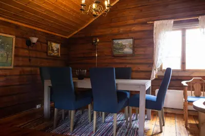 a dining room with a table and blue chairs at Skanckegårdene AS in Røros
